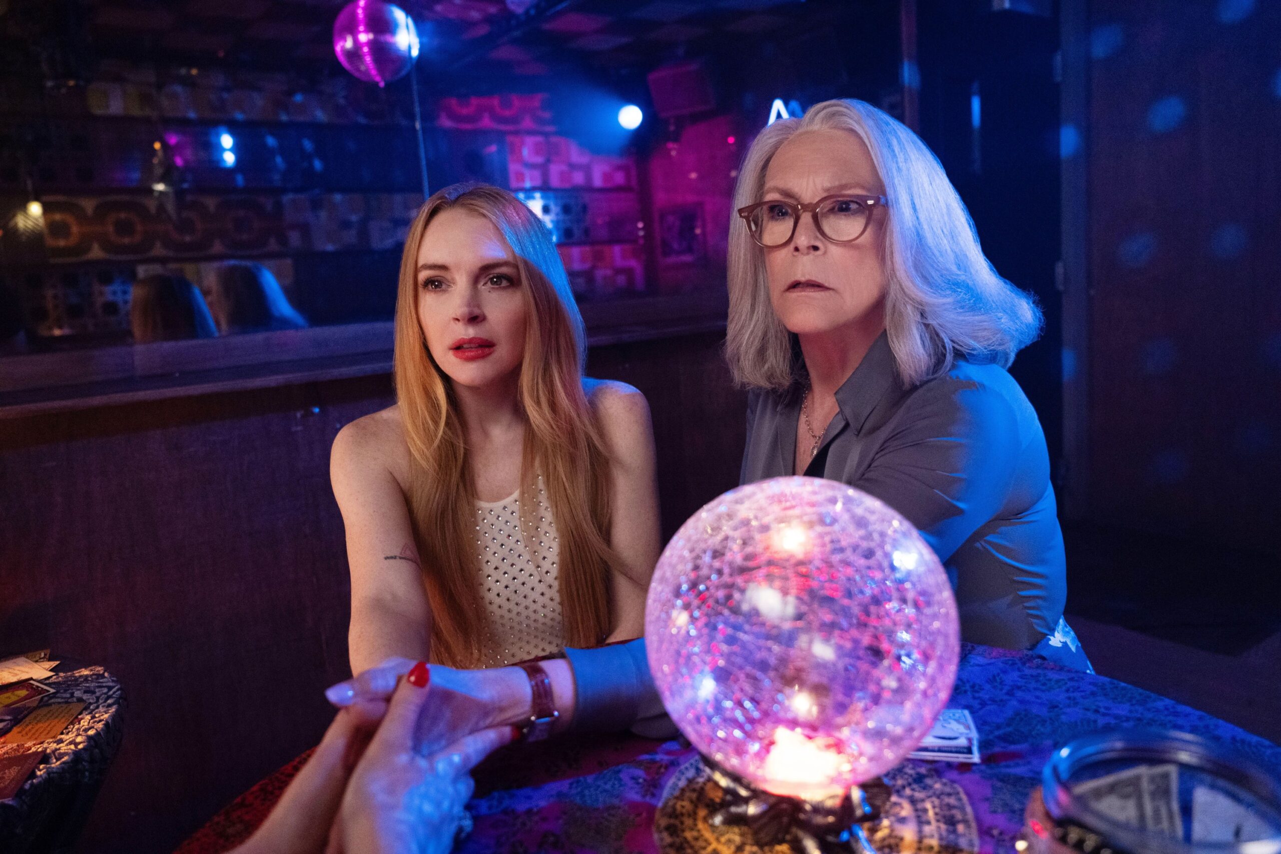 Dos personas en mesa con bola de cristal